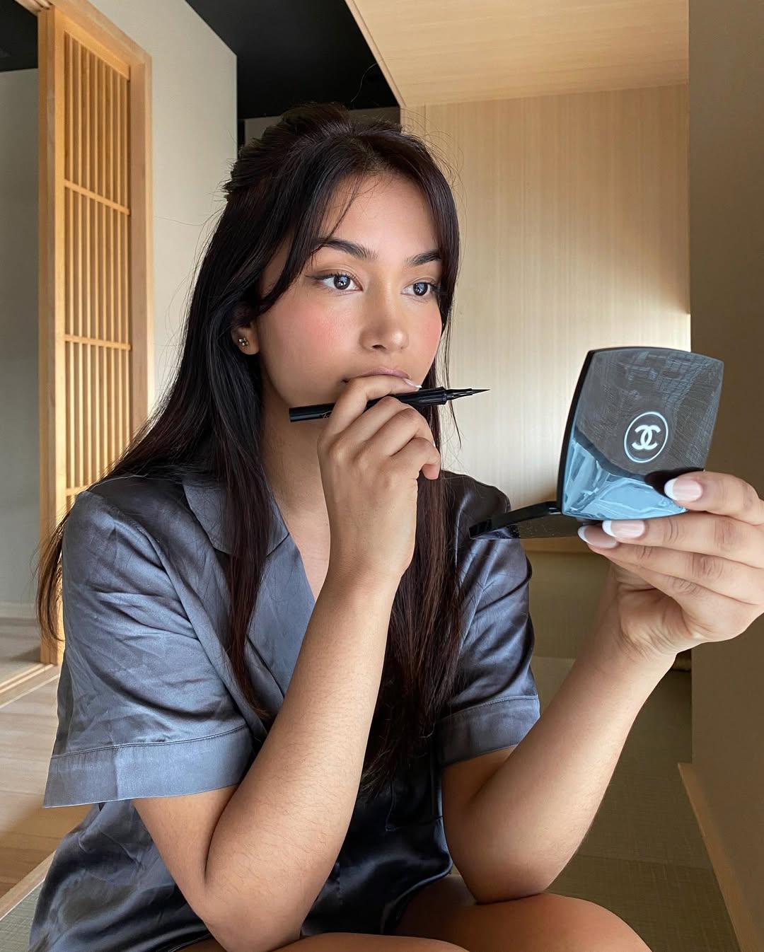 Content creator Mishti Rahman applies winged eyeliner while visiting Shinjuku, Japan