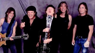 AC/DC standing in front of a grey backdrop
