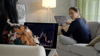 how to invest in stocks as a beginner shows two people looking at stock charts
