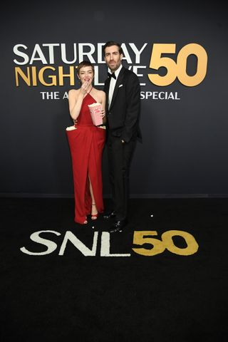 Emma Stone wears custom Louis Vuitton with huge pockets filled with popcorn on the red carpet at SNL50