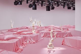 Acne Studios S/S 2023 show set with shell encrusted chandeliers on pink background