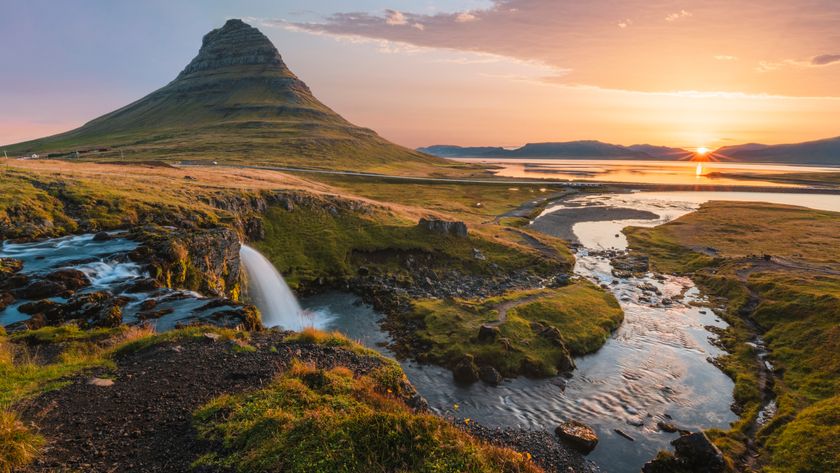 Mount Kirkjufell and Kirkjufellsfoss waterfall at sunrise in Iceland.