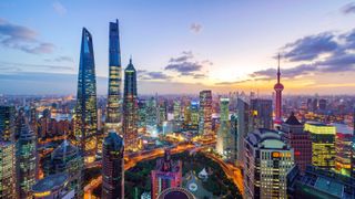 Shanghai, China, with city lights lit up colorfully at night.