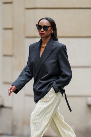 woman wearing black blazer and cream trousers