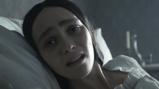 Lily-Rose Depp looking scared while in bed in Nosferatu