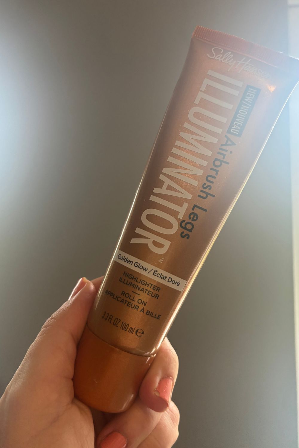 a hand holding a tube of sally hansen airbrush legs illuminator