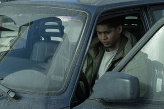 Rhenzy Feliz as Victor Aguilar, sitting in the front seat of a car on a rainy day, in 'The Penguin.'