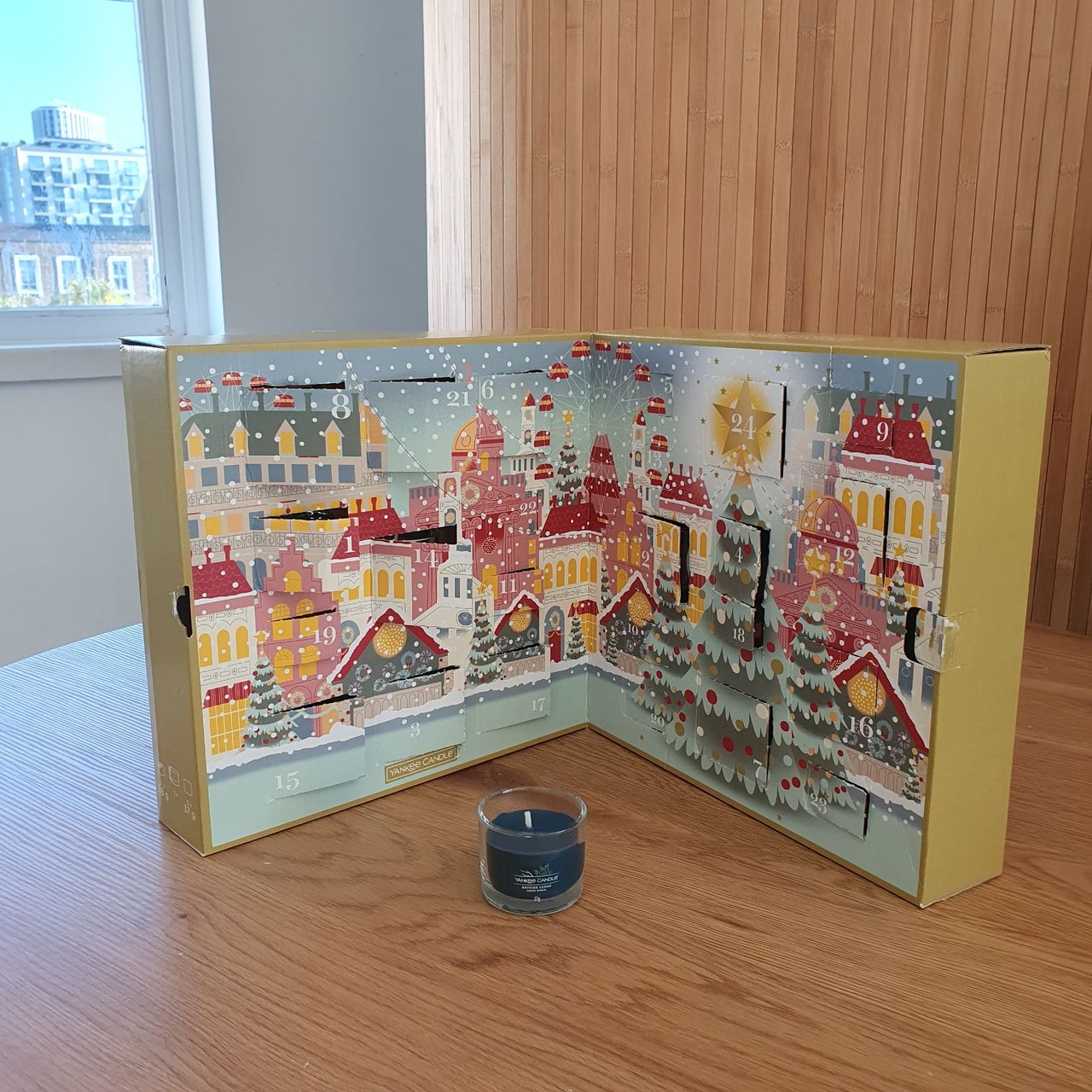 The Yankee Candle Advent Book 2024 on a table set against wood-panelled background