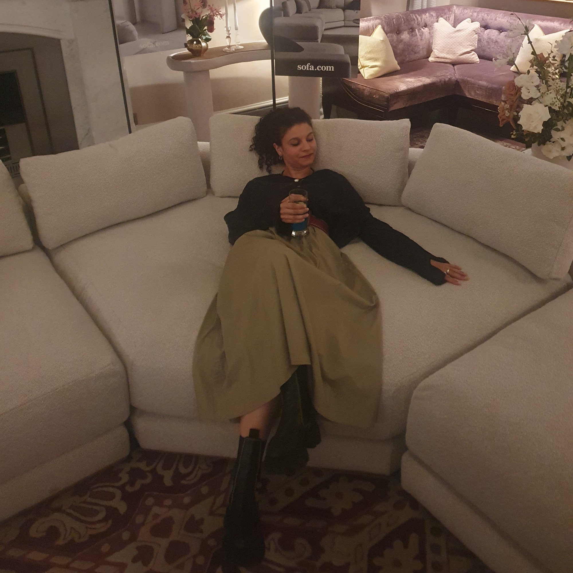 Sara lying down on the Sloane modular corner sofa from sofa.com at a launch event