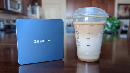 The Geekom Mini IT13 next to a Grande-size Starbucks drink. 