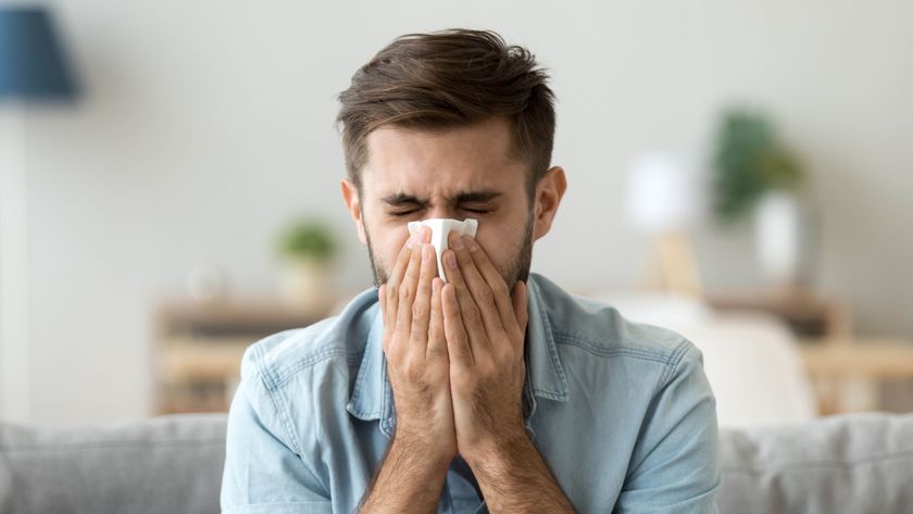 Man sneezing into tissue