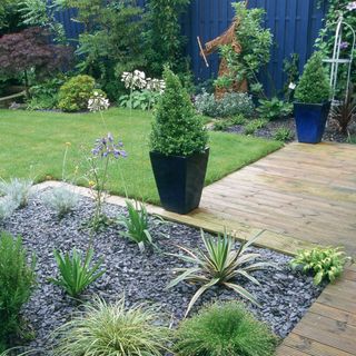 green lawn with wooden floorboard and potted plant