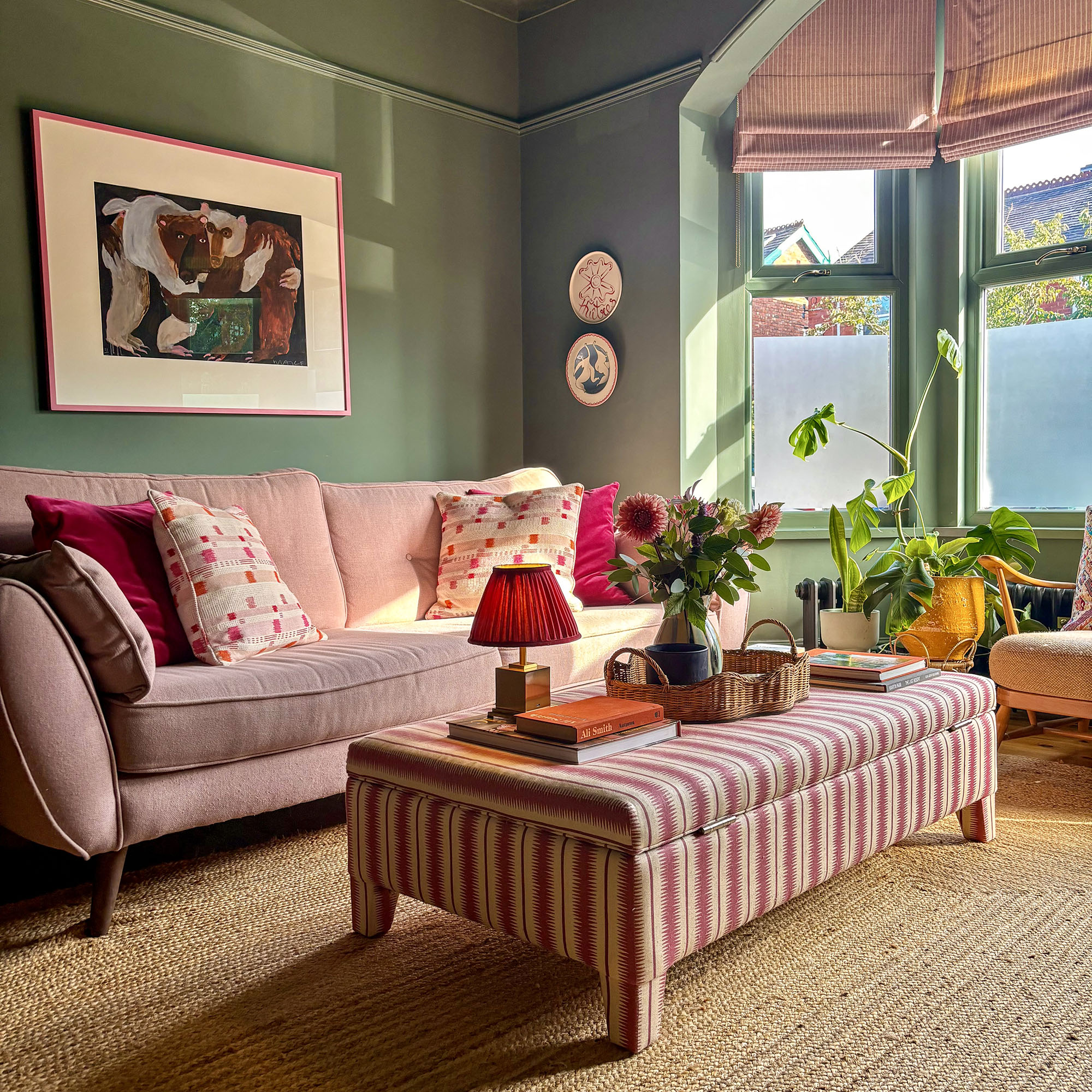 green living room with striped ottoman and striped blinds