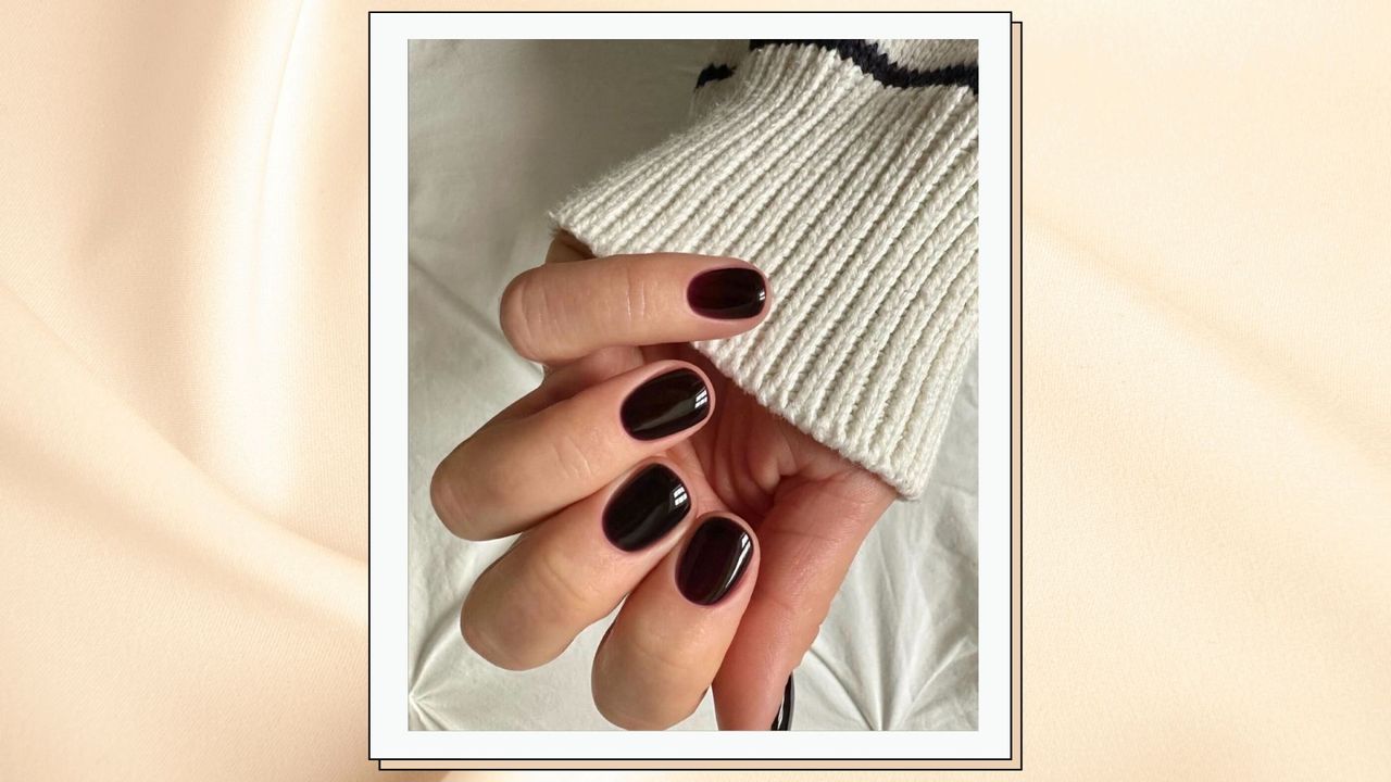 close up of woman&#039;s hand wearing dark red nails