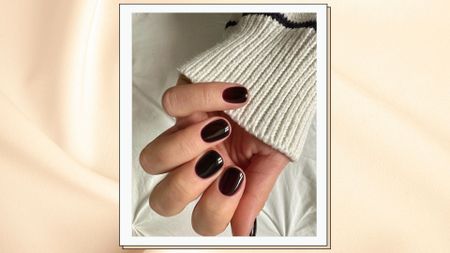 close up of woman's hand wearing dark red nails