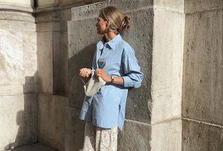 An influencer wears a blue button-down shirt.