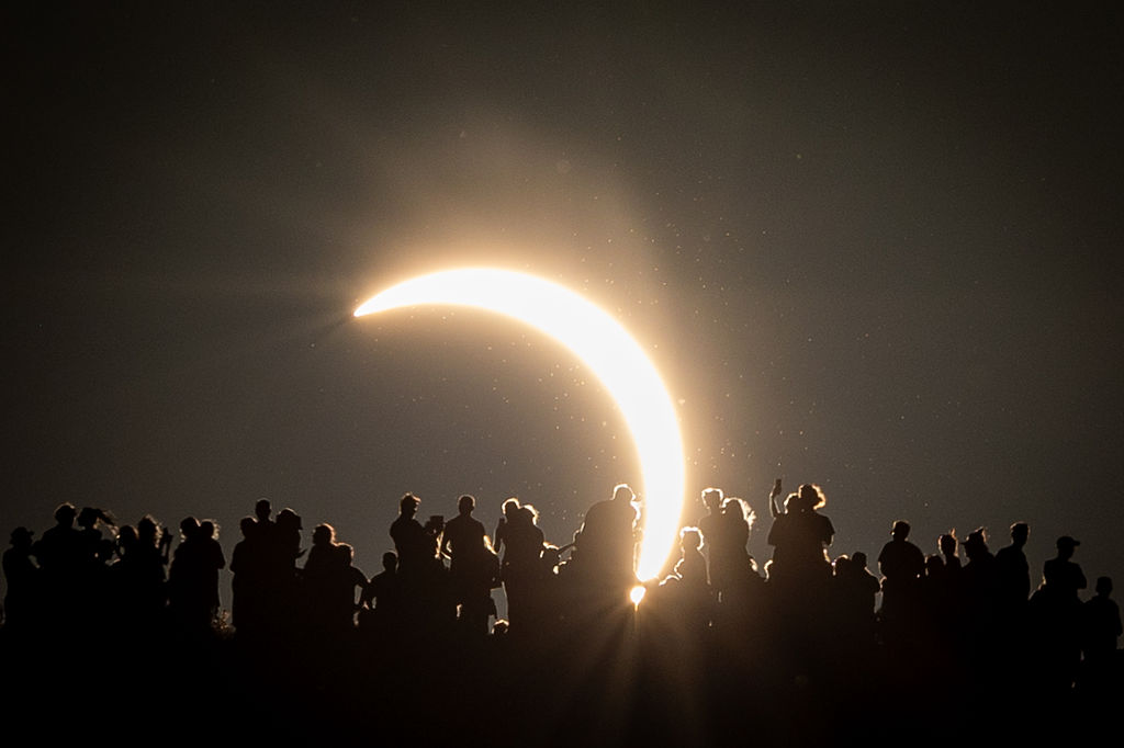 People view the partial solar eclipse besides the historic St. Michael's Church tower, a Grade I listed building at the top of Glastonbury Tor on August 12, 2026 in Glastonbury, England. (Photo by Matt Cardy/Getty Images)