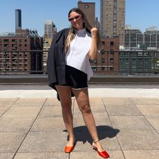 Writer Irina Grechko in black track shorts with white button-down and black blazer.