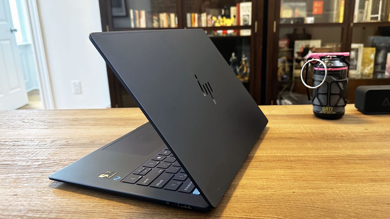 A laptop with its lid open, shown at an angle on a wooden desk.