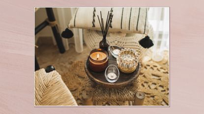 Image showing a small table with candles and a diffuser with chairs around the edge of the frame