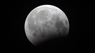 This photograph shows a full moon before the peak of the penumbral eclipse as seen from Pakistan's capital of Islamabad late August 7, 2017.