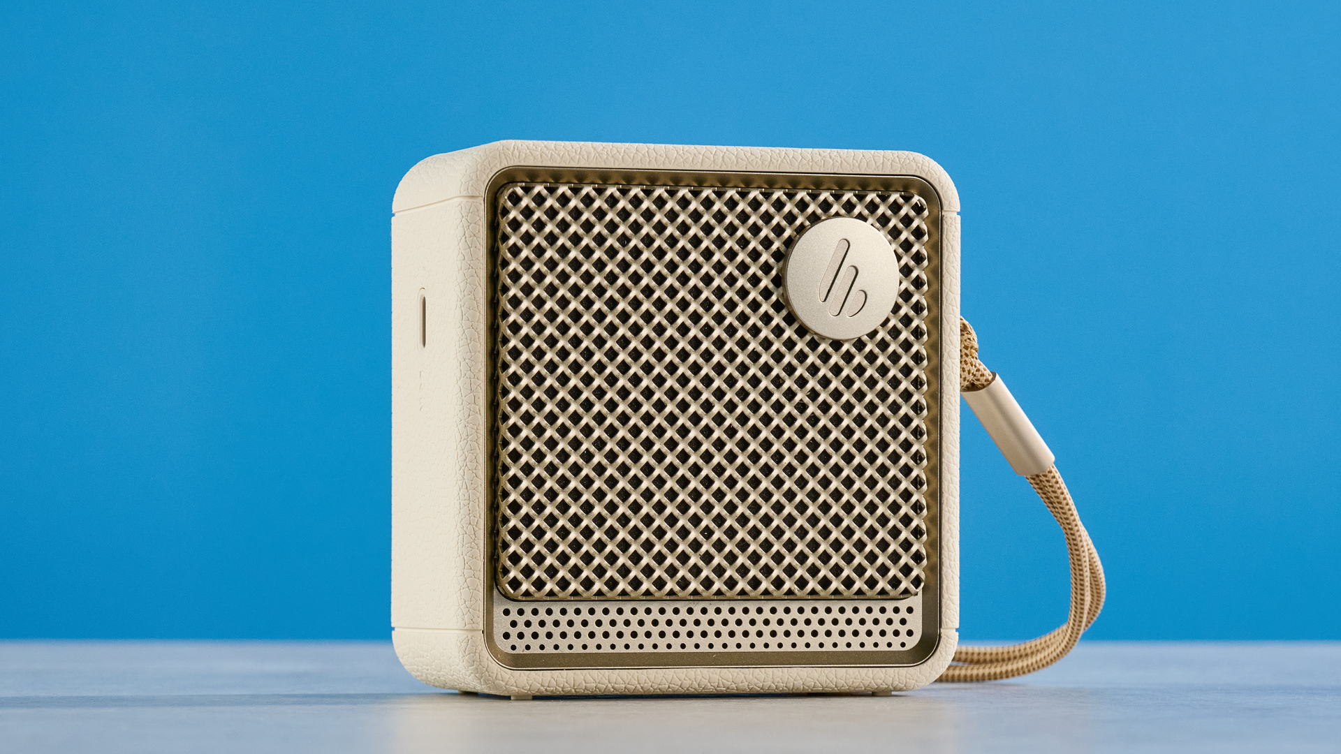 Edifier ES20 Bluetooth speaker in ivory colorway photographed on a blue background