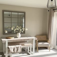 A living space with a dining table and a mirror above it painted in Egyptian Cotton by Dulux