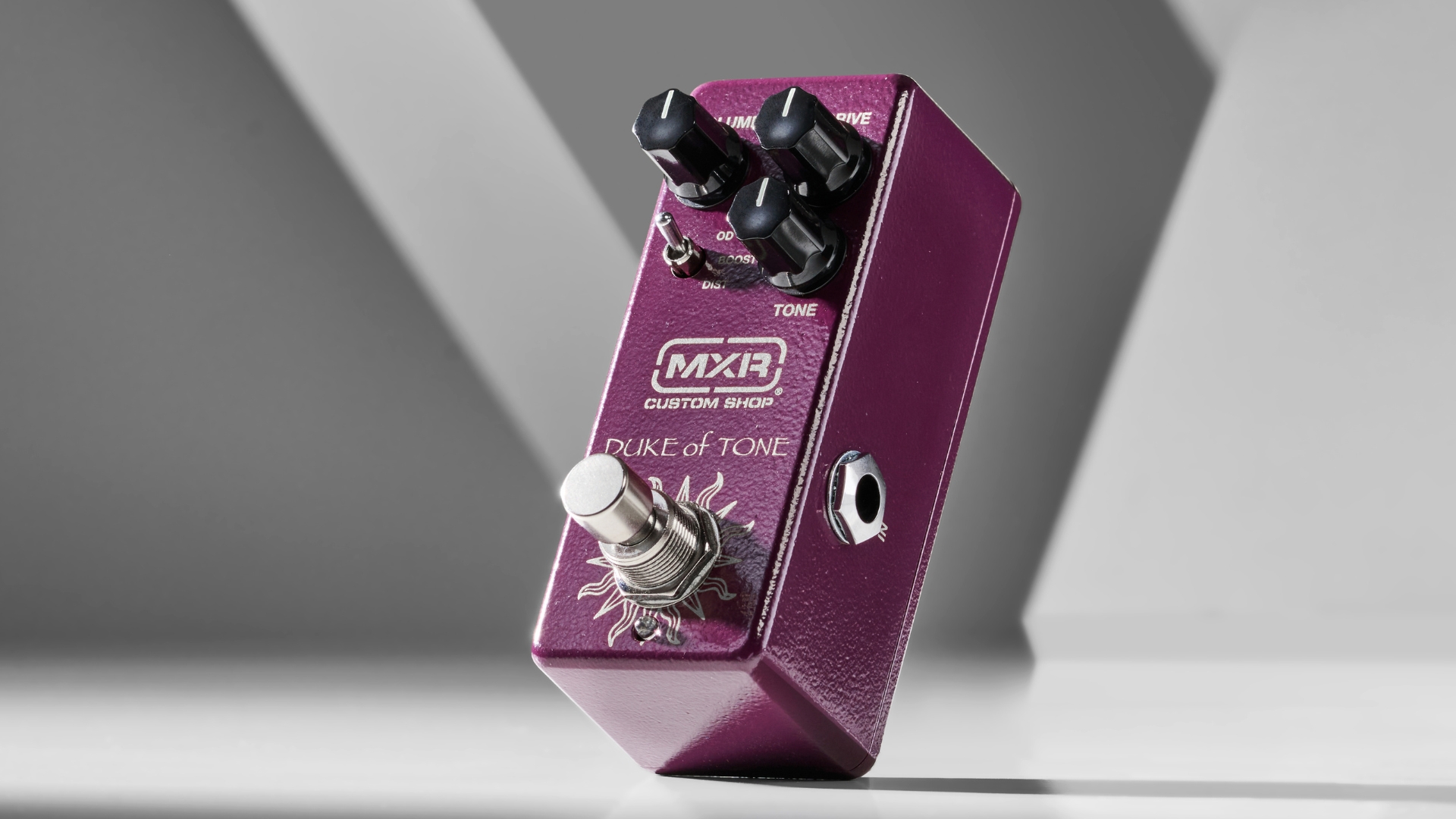 An MXR Duke Of Tone overdrive pedal on a grey background