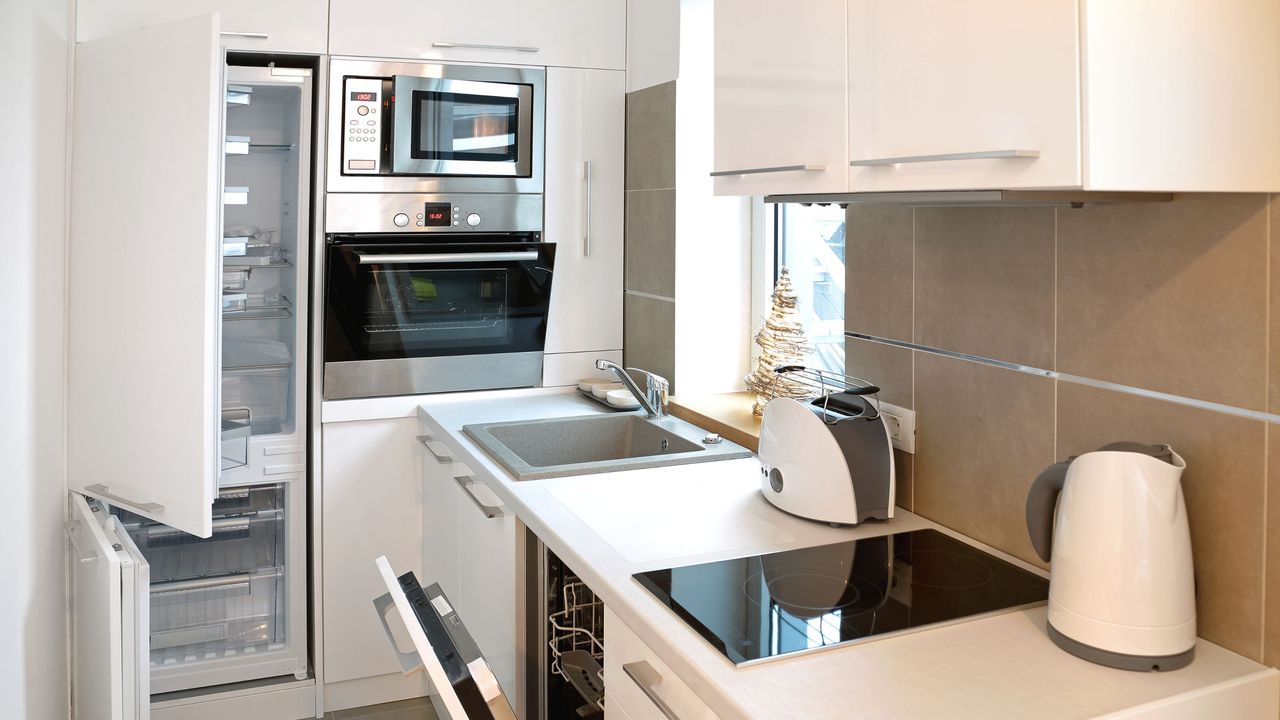 Small kitchen with a cooker, counters and a fridge