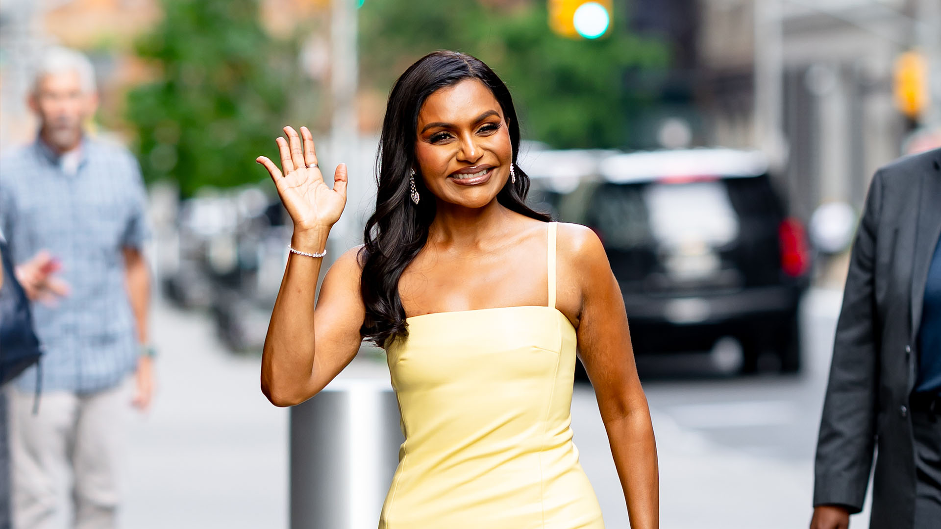 Mindy Kaling wearing a yellow dress and Christian Louboutin clear heels 