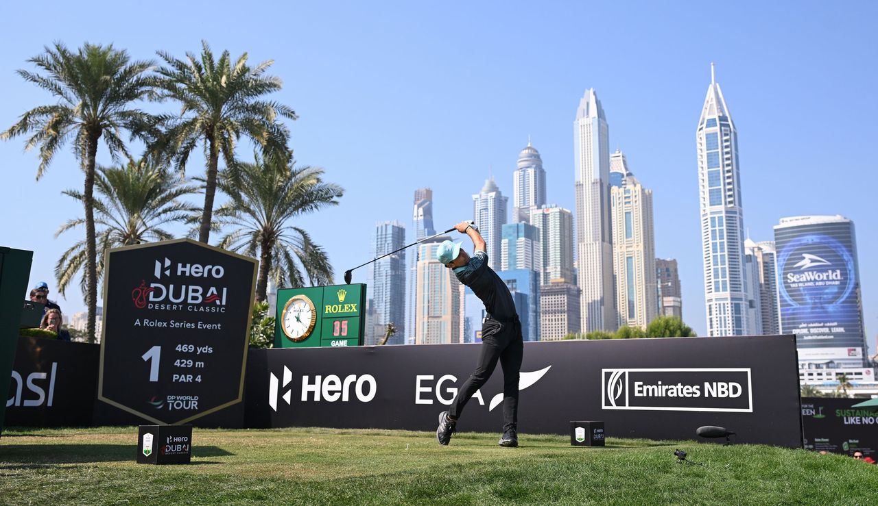 Joaquin Niemann hits his tee shot off the opening hole in front of the Dubai skyline