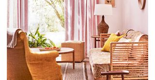 70s inspired interior design living room with a warm color palette with a rattan sofa and curved coffee table and side table