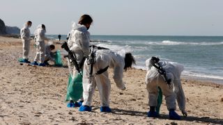 Israeli soldiers remove tar balls during cleanup operation at the Sharon beach national park on Feb. 22.