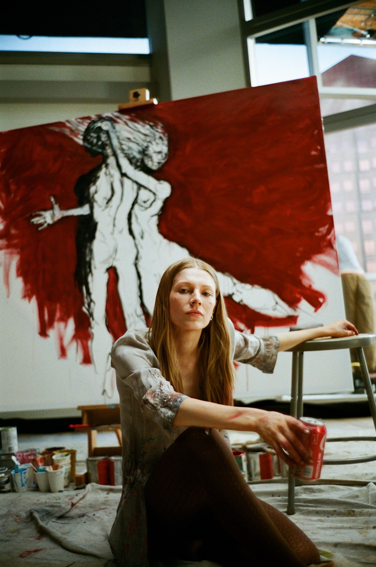hunter schafer as jules sitting on the floor of an art studio painting a giant piece in euphoria season 3