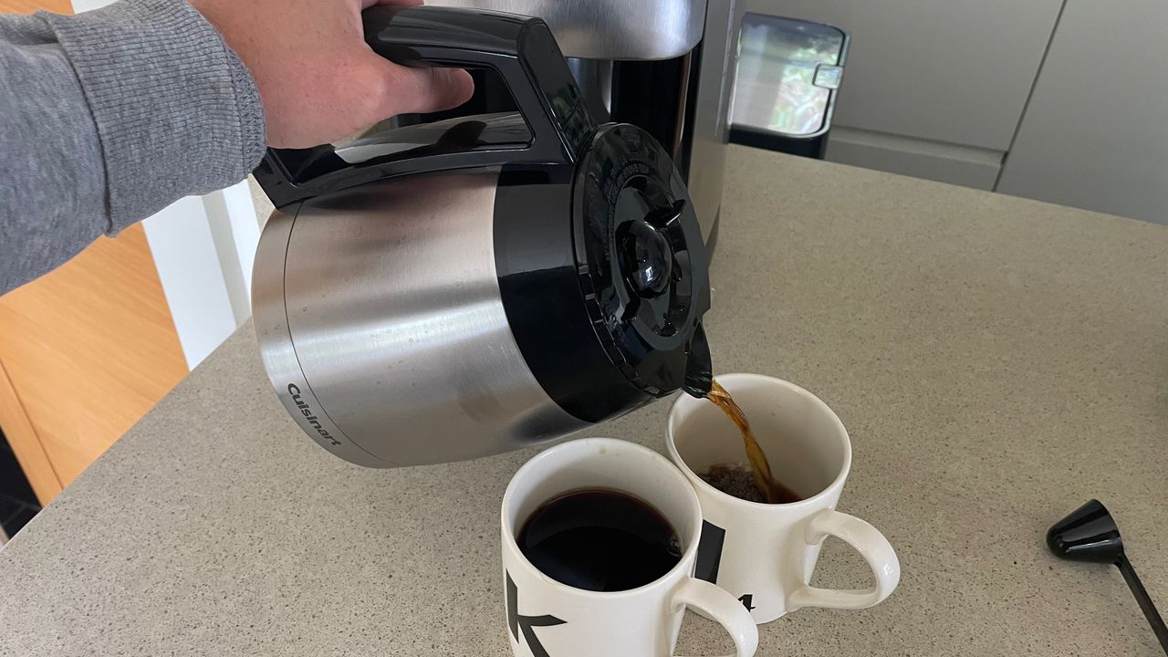 pouring coffee from the carefe that comes with the Cuisinart Grind &amp; Brew