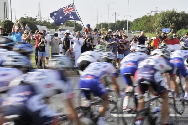 The peloton is cheered on by an Australian fan.