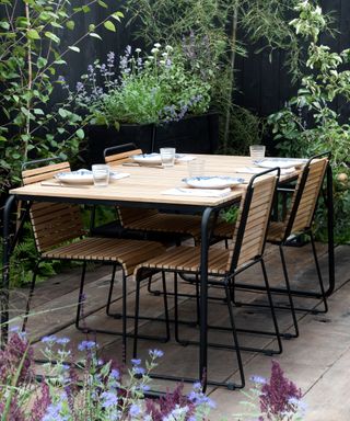wooden outdoor dining table and chairs on a patio