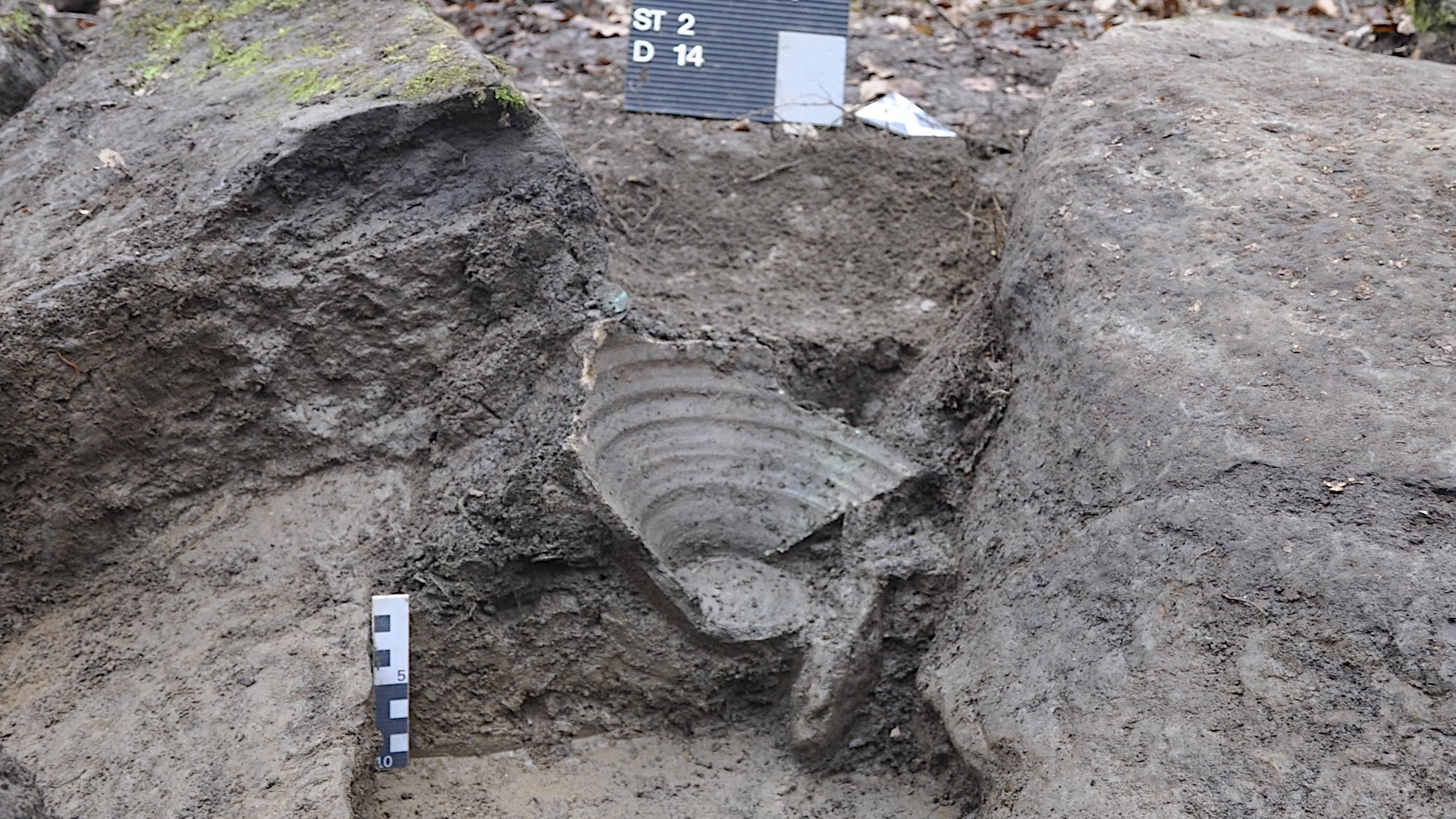 The fragment of a ceramic pot in the dirt