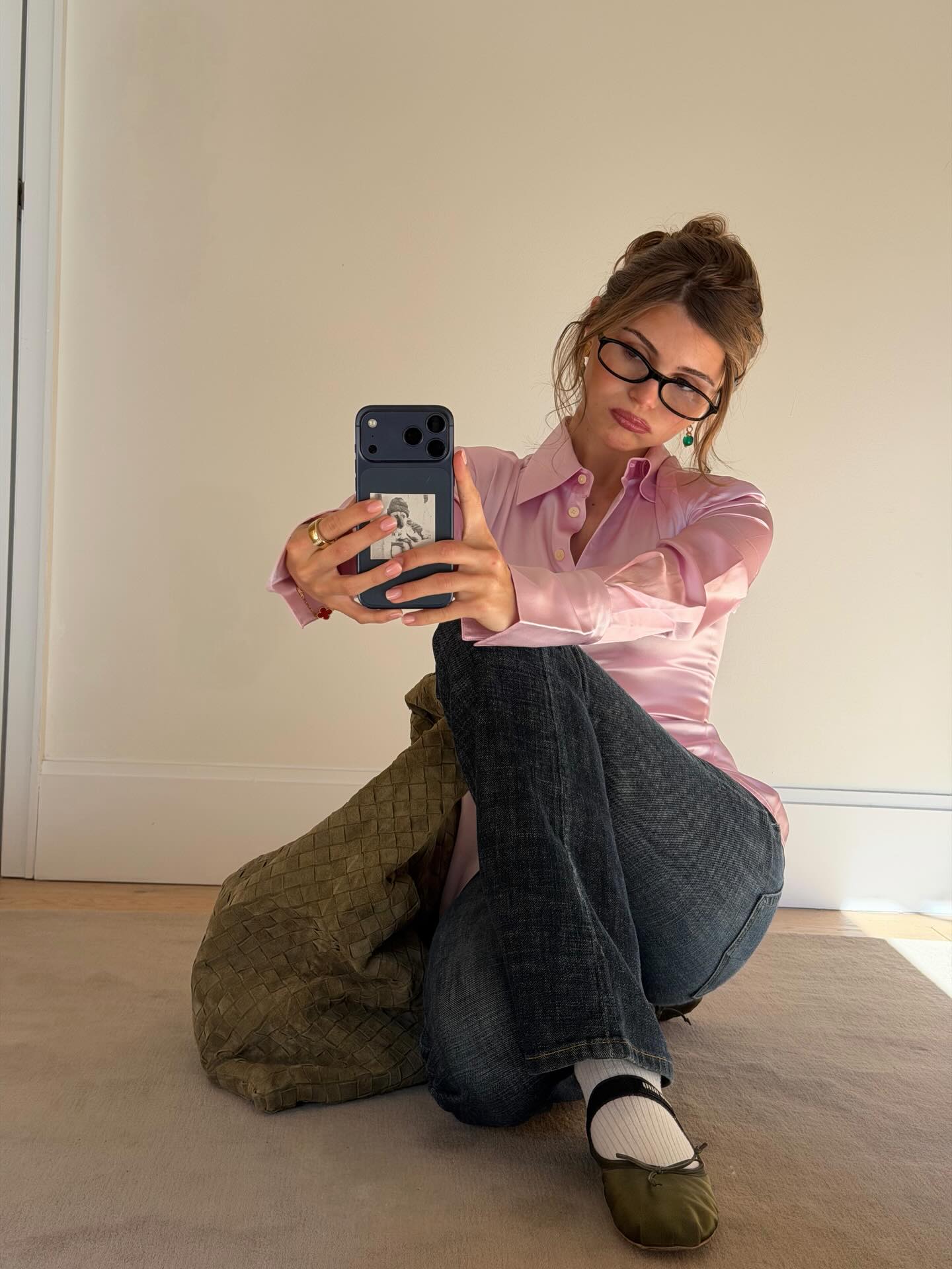 Woman wearing a satin top and jeans.