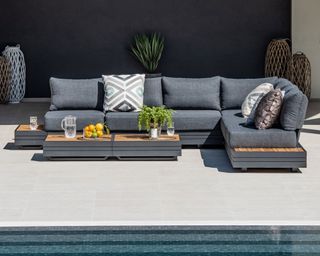 modern grey outdoor corner sofa on a patio next to a pool