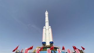 A Chinese Long March 2F rocket for the Shenzhou 16 crew with Chinese flags rolling out to the pad