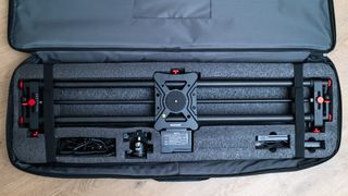 Neewer ER1 Motorized Carbon Fiber Camera Slider in its soft padded case on a wooden surface