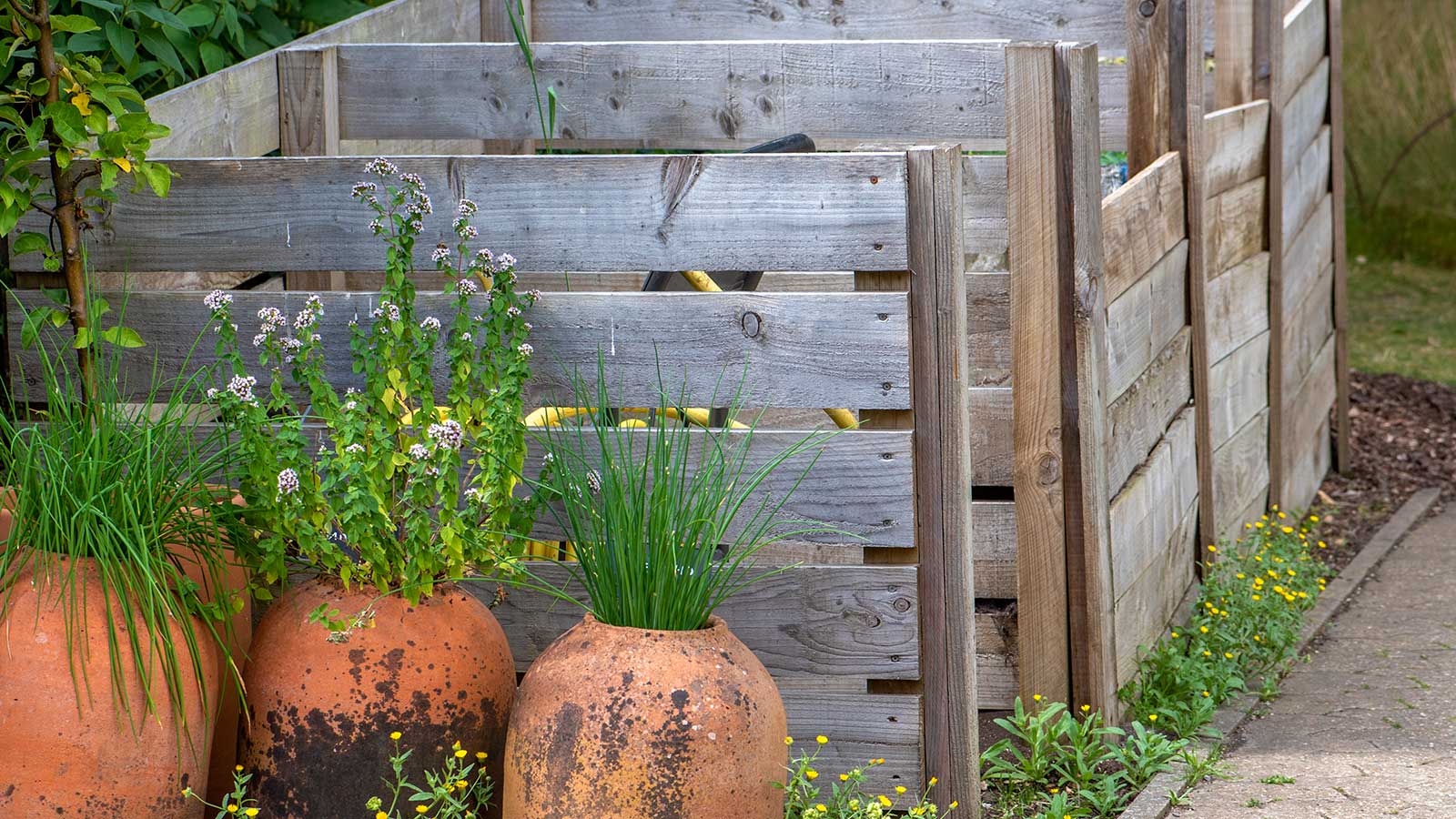 wooden compost bins with pot plants