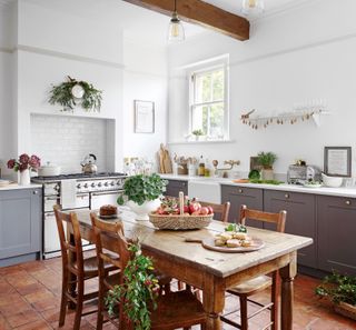 traditional-style kitchen with range cooker grey base units quarry tiles and vintage table and chairs