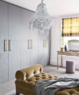 Dressing room with wallpapered wardrobes and beaded chandelier