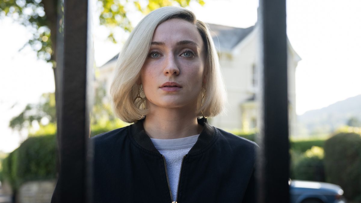 Joan episode 5 Joan looks worried while peering through a gate