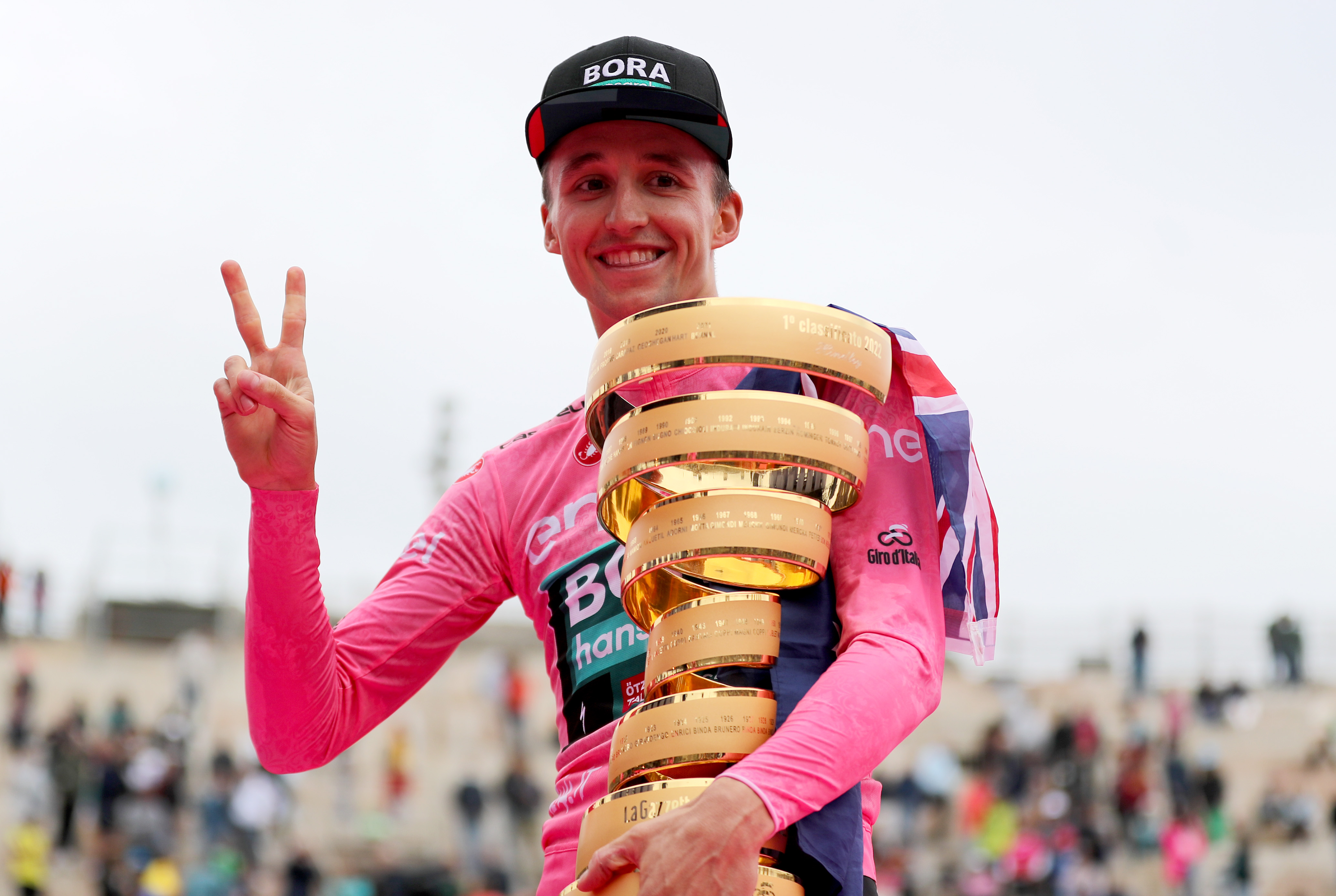 Jai Hindley throws a peace sign while holding his Giro d'Italia trophy