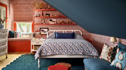 loft with bed and floating shelves, with patterned red wallpaper, and a blue painted sloped roof