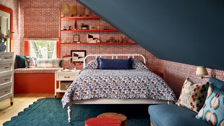 loft with bed and floating shelves, with patterned red wallpaper, and a blue painted sloped roof