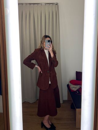 Eliza Huber in the dressing room at Madewell's new SoHo flagship in New York wearing a brown suede blazer and matching midi skirt.